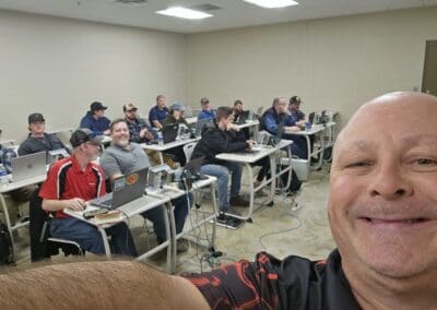 Gallery 69 Group of students in a classroom with laptops, instructor taking selfie in foreground.