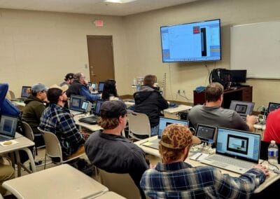 Gallery 71 Classroom with students using laptops and virtual reality headsets for training.