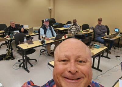 Gallery 76 Group of professionals in a training room with laptops and equipment at Automated Dynamics Corp.