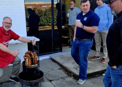 Gallery 80 Group of men enjoying barbecue outside during daytime at Automated Dynamics Corp. event.