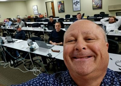 Gallery 85 Group of professionals in a conference room with laptops, smiling and taking a selfie.