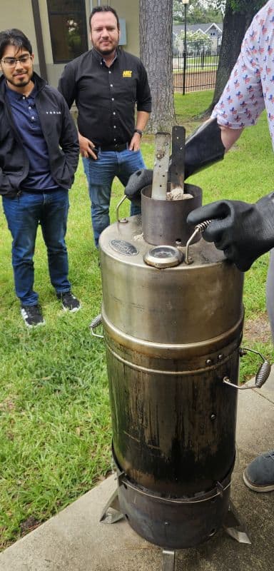 Gallery 108 Automated Dynamics Corp. engineers testing a rocket engine in outdoor setting with onlookers.