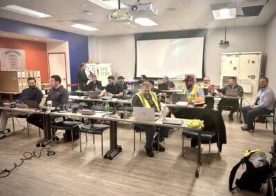 Gallery 16 Team of professionals in a modern training room with laptops and presentation equipment.