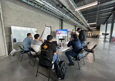 Gallery 20 Team meeting in industrial-style conference room with whiteboard and presentation screen.