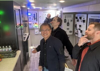 Gallery 30 Automated Dynamics Corp. team members exploring technology displays at a trade show or exhibition.