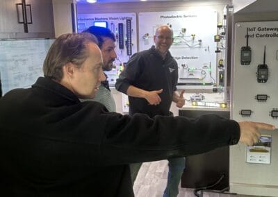 Gallery 31 Group of people examining electronic control panels at Automated Dynamics Corp. gallery.