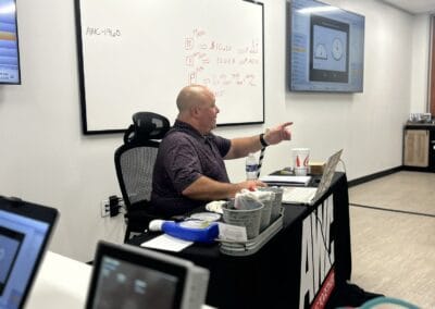 Gallery 35 Businessman giving presentation in a modern conference room with whiteboard and digital screens.