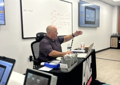 Gallery 36 Businessman giving presentation in modern office with whiteboard and monitors.