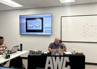 Gallery 39 Business meeting with laptops and presentation screen in a modern conference room at Automated Dyanm.