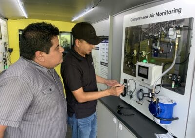 Gallery 49 Two men examining compressed air monitoring equipment at Automated Dynamics Corp. gallery.