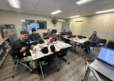 Gallery 53 Group of six people in a meeting room with laptops and equipment, smiling and working together.