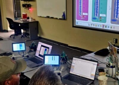 Gallery 9 Team analyzing digital maps and data on multiple screens in a conference room.
