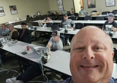 Gallery 10 Group of students in a classroom with a teacher taking a selfie in the foreground.